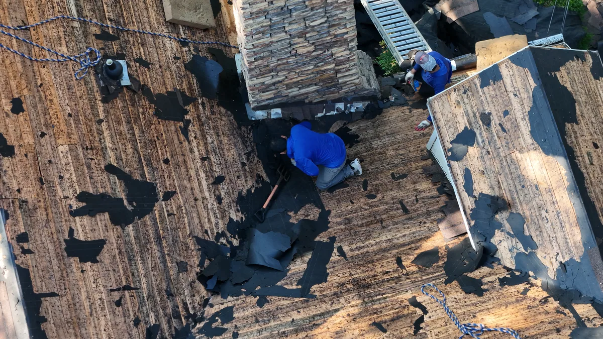 Roof tear-off in progress with crew removing old shingles on a McMinnville, TN home