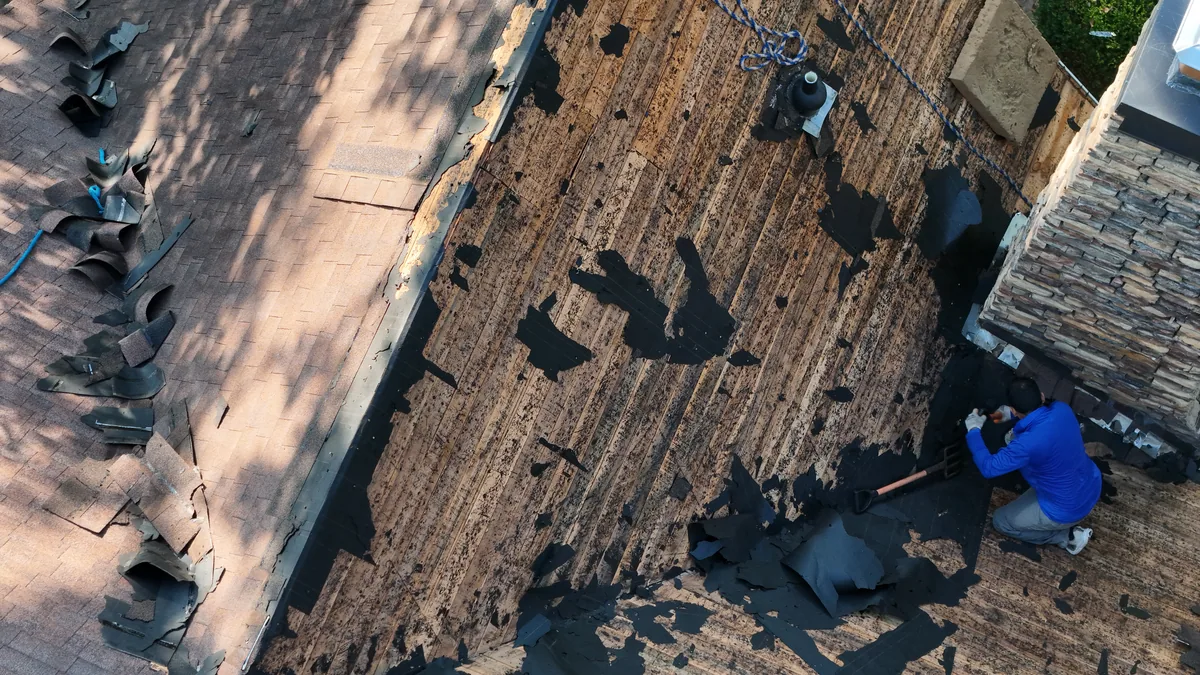 Crew stripping shingles down to the deck during a McMinnville, TN roof replacement