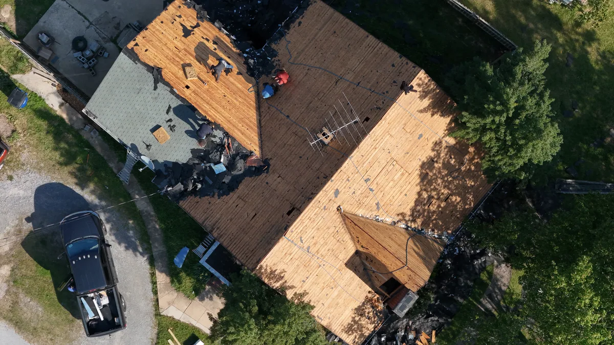 Roof tear-off in progress with crew on exposed decking, Shelbyville, TN, morning of April 14, 2025