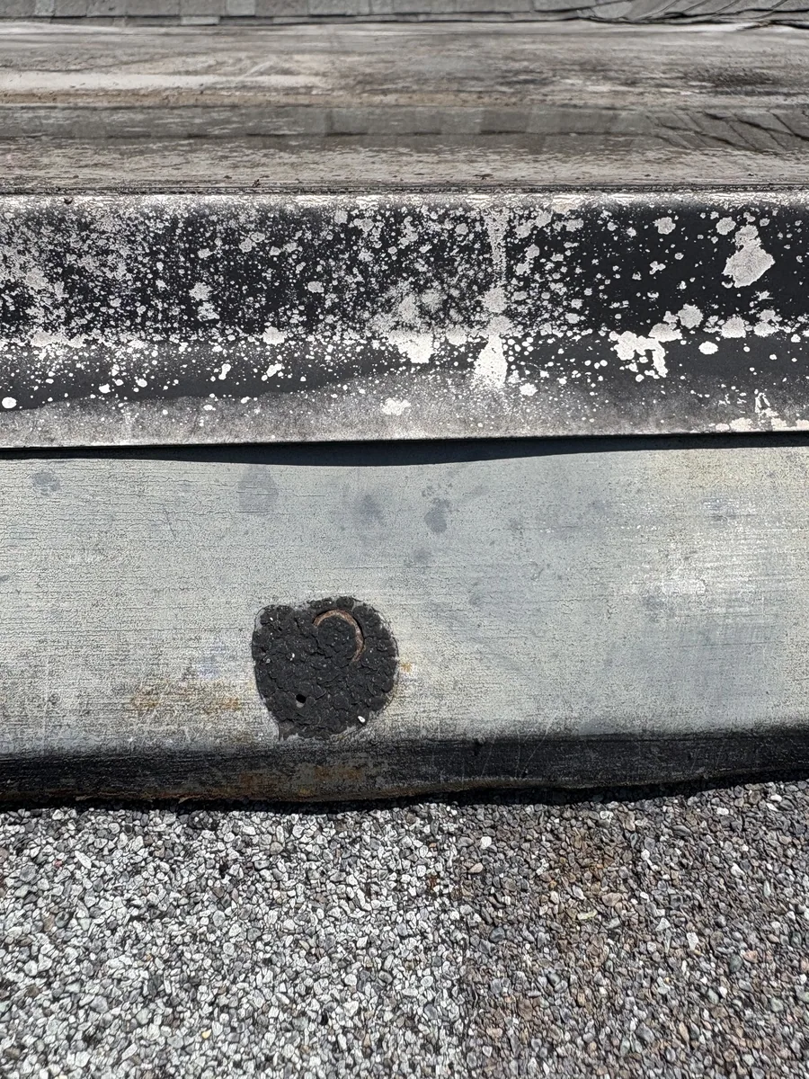 Shingle granules accumulated in a gutter, evidence of hail-stripped granule loss