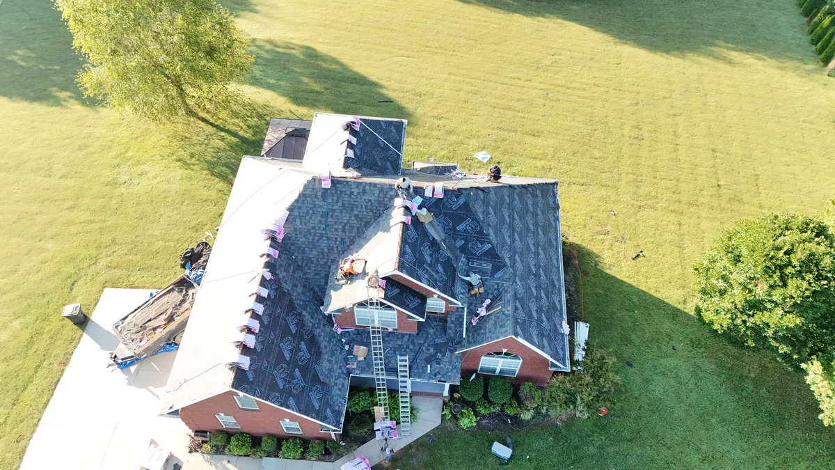 Roof replacement in progress with materials on the ridges of a large Bedford County, TN home