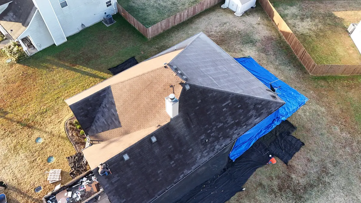 Storm-worn roof with tarp in Christiana, TN before replacement by Blue Raider Roofing.